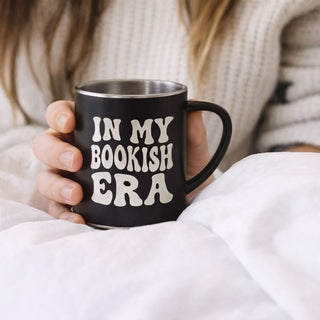 Person holding black mug with “In My Bookish Era” text, cozy reading gift under £30 for book lovers