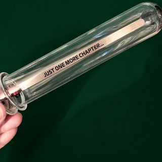 A hand holding a clear glass test tube with a F1 car bookmark