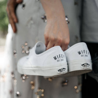 Bride holding personalised Vans wedding trainers with Wifey Est year design