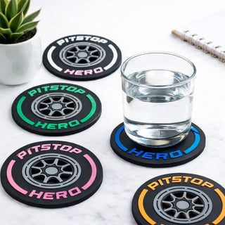 Set of  F1 'Pitstop Hero' coasters with a glass of water on a marble surface.