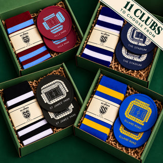 Four green gift boxes arranged on a dark green background, each containing a pair of striped socks and a round stadium patch with club names and stadium names. A banner in the top right reads '11 CLUBS TO CHOOSE FROM'.