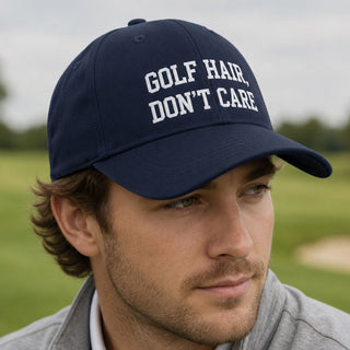 Man wearing a navy Golf Hair Don't Care cap on a golf course, funny golf gift for golfers, dads and golf lovers.