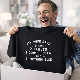 Man laughing while receiving funny husband gift t-shirt that says "My wife says I have 2 faults I don't listen and something else"