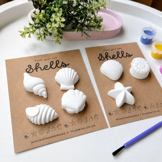 Unpainted and hand-painted ceramic shells from the Paint Your Own Shells Kit