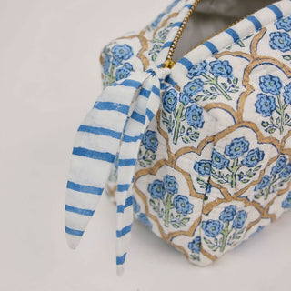 Close up of quilted block print makeup bag with striped fabric zip pull