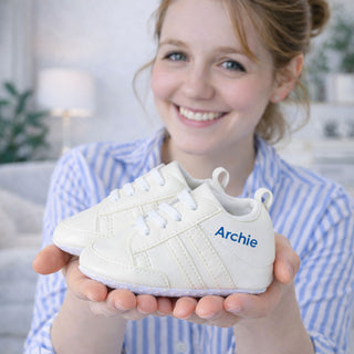 Personalised baby trainers with custom name held in hands, perfect new baby gift idea for boys or girls