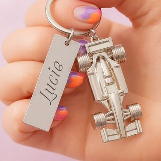Close-up of a personalised Formula 1 car keyring with engraved name tag, held in hand