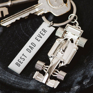 Personalised Formula 1 keyring with silver F1 car charm and engraved tag reading "Best Dad Ever" attached to a set of keys.