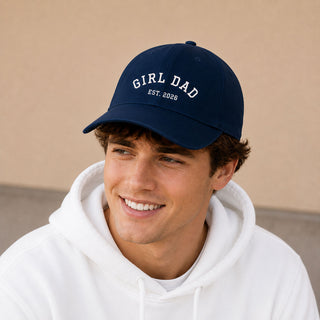 Young man wearing a navy personalised Girl Dad EST 2026 Father’s Day baseball cap with white printed text