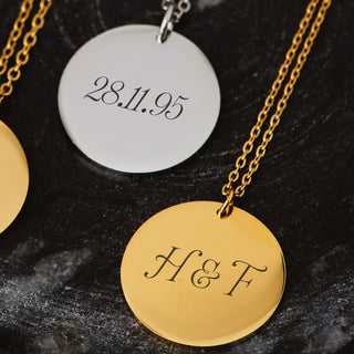 Close-up of personalised Victorian love token necklace showing engraved initials on front and meaningful date on back