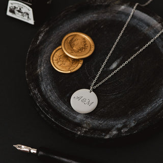 Personalised silver Victorian love token necklace engraved with couple’s initials on a round disc pendant