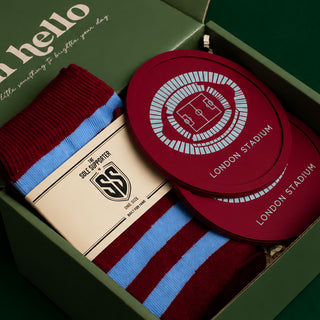 A London Stadium themed gift set in a dark green box, featuring maroon and light blue striped socks, a cream paper sleeve with a 'Sole Supporter' logo, and round maroon coasters printed with the stadium design.